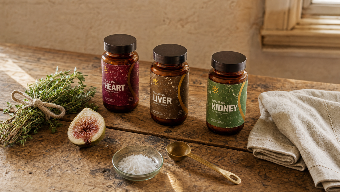 Editorial table layout of Vital Origin organ supplement tins with thyme, figs, sea salt and brass spoon in golden hour.